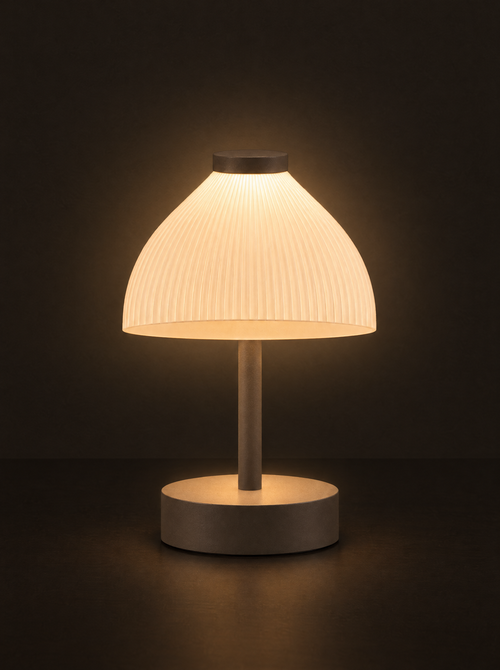 Cloche table lamp: a ribbed dome shade glowing above a slim stem and round base