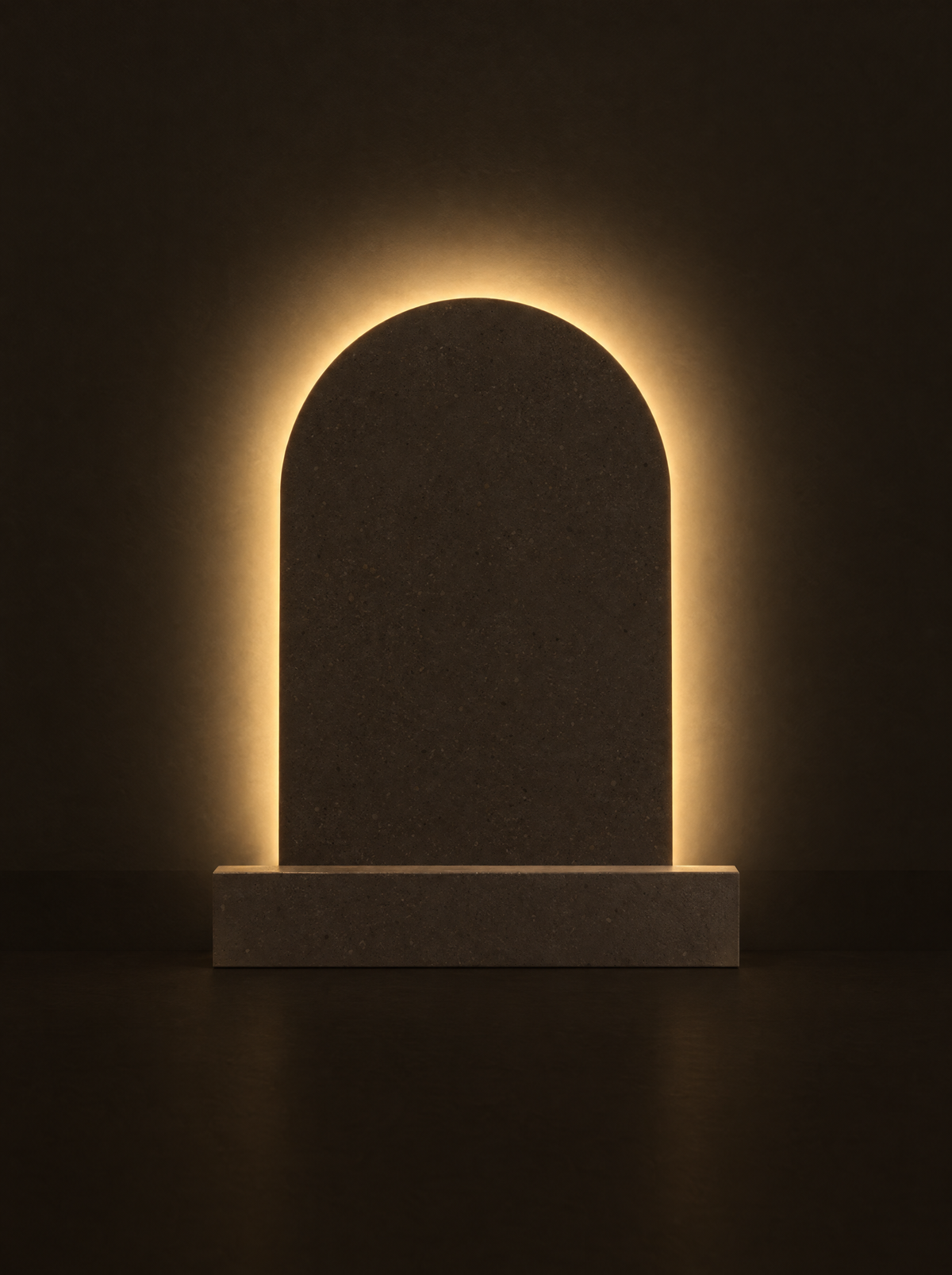 Volta lamp: a stone-toned arch on a plinth with a warm halo glowing on the wall behind it